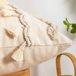 coussin beige et coloré à motifs brodés